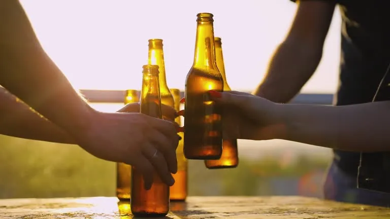 imageye___-_imgi_12_friends-drinking-beer-outdoors-bottles-in-hands-closeup.webp